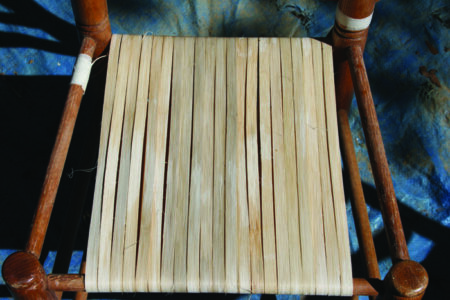 Closeup of canes wrapped around a seat going in one direction, in a row, before…